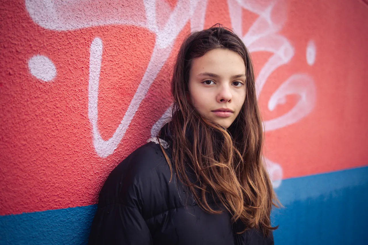 Jugendliche vor einer farbigen Wand mit klarem Ausdruck